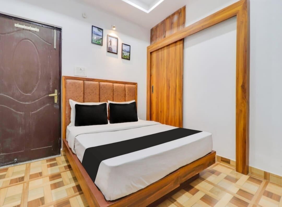 Une chambre à coucher avec un cadre de lit en bois, une grande armoire et une porte ornée d’un panneau décoratif.