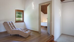 Une pièce spacieuse avec une grande fenêtre, un fauteuil confortable et un plancher en bois.