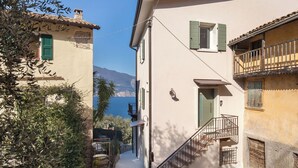 A narrow street with buildings on either side, a clear view of the sea, and a staircase leading to a balcony. - Casa Sofia - Lake view, Casa Sofia - Casa vista lago (Pai)