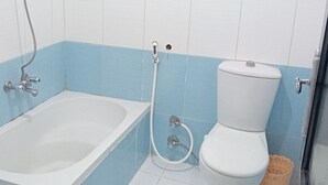 A bathroom with a bathtub, toilet, and shower. - Furnished apartment for rent in miamiAlexandria (Alexandria Governorate)