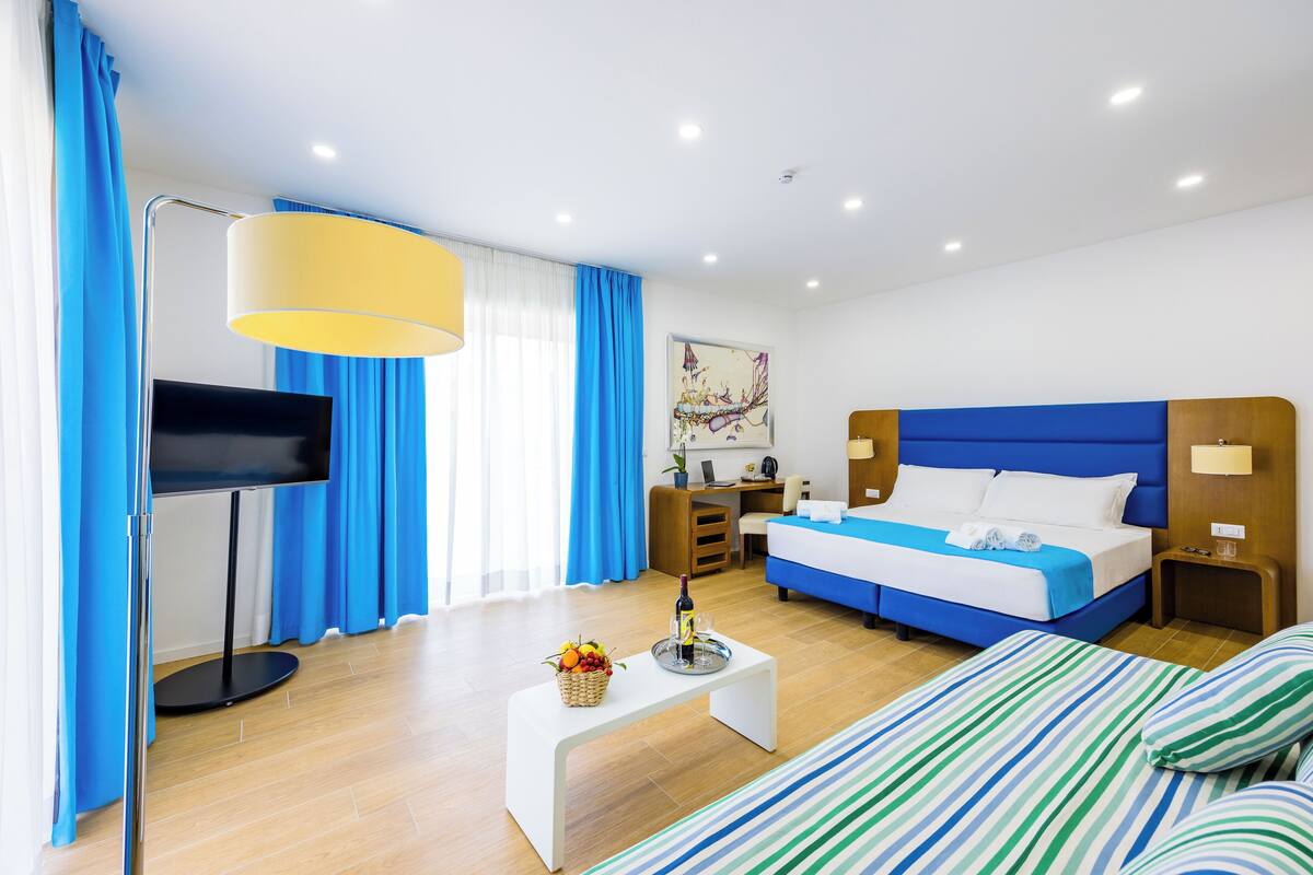 Deluxe Triple Room, Balcony, City View | Desk, laptop workspace, blackout drapes, iron/ironing board