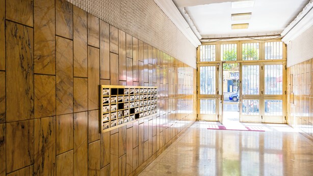 A hallway with wooden paneling and a row of lockers on the left. - Carlo III guest house (Naples)