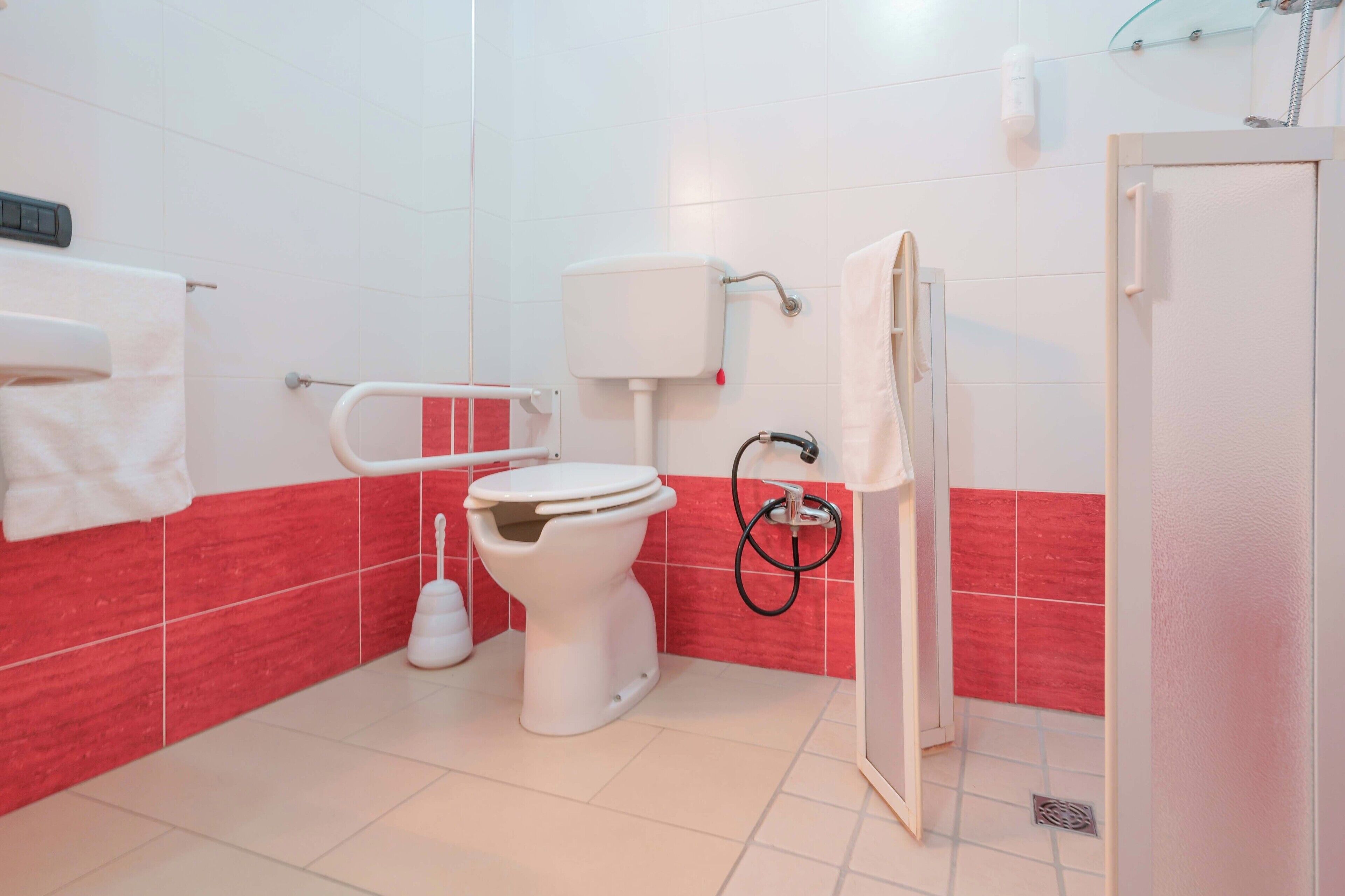 A bathroom with a toilet, bidet, and shower.