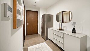 Eine moderne Küche mit Kühlschrank, einem weißen Schrank und einem Spiegel.
