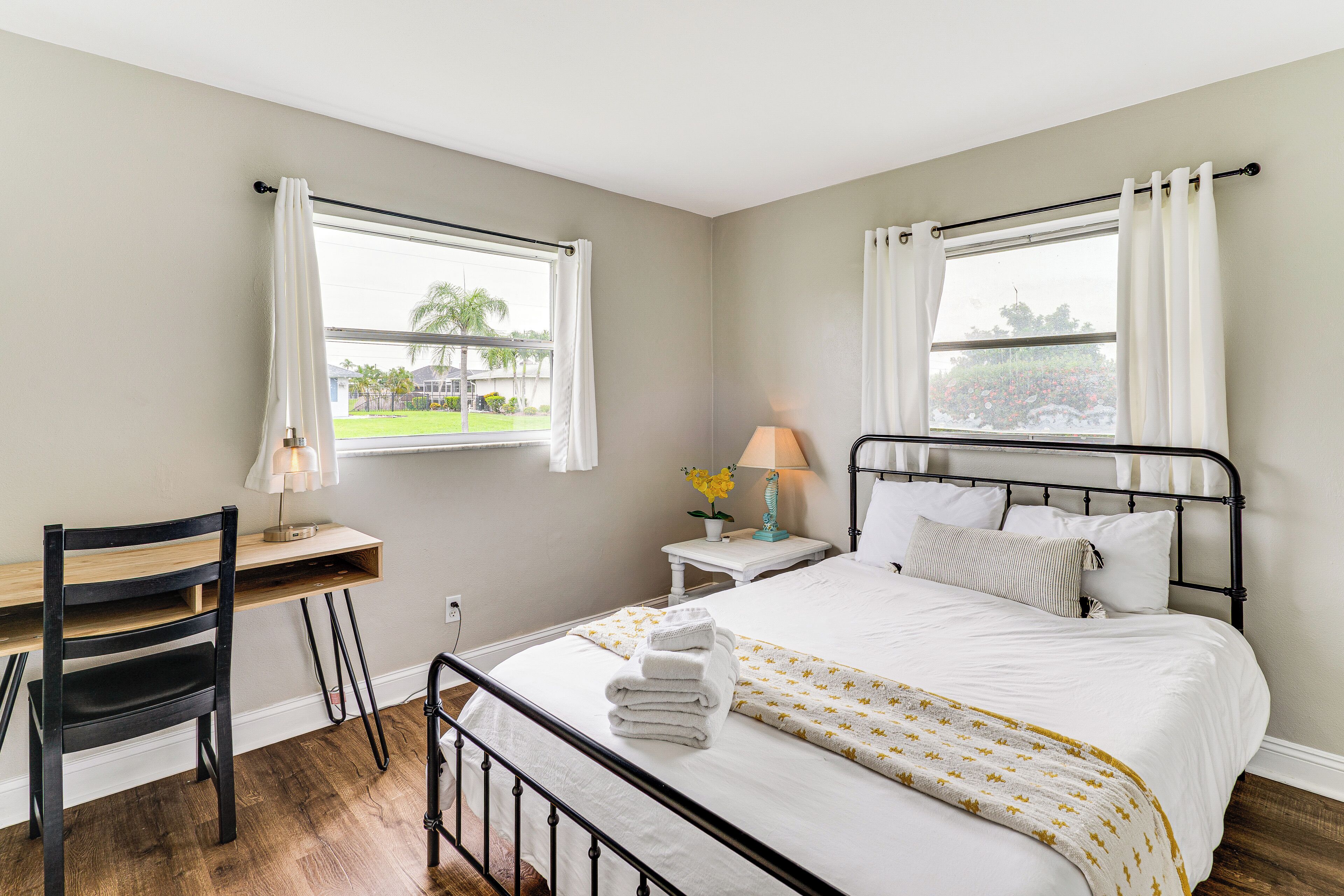 A bedroom with a bed, a desk, and a chair.