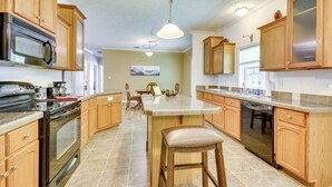 A kitchen with wooden cabinets, a stainless steel oven, a microwave, and a dishwasher. - Peaceful Family Retreat in Winston-salem (Winston-Salem)