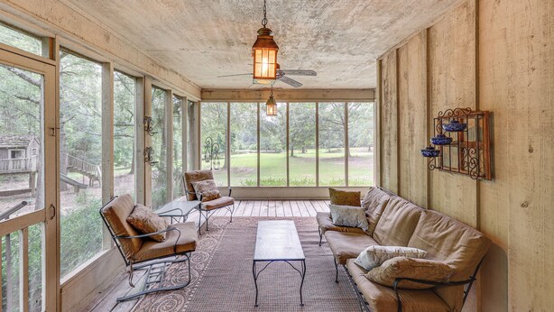 A covered porch with a ceiling fan, a table, and two sofas. - Waterfront Home w/ Playground Near Degray & Caddo! (Arkadelphia)