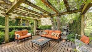 An outdoor patio with wooden furniture, a pergola, and a grill area. - Waterfront Home w/ Playground Near Degray & Caddo! (Arkadelphia)