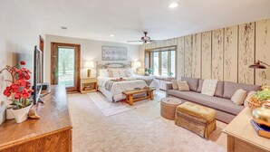 A spacious bedroom with a large bed, bedside tables, a wooden desk, and a window with a view. - Waterfront Home w/ Playground Near Degray & Caddo! (Arkadelphia)
