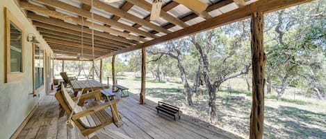 A covered outdoor area with wooden benches and a ceiling fan.