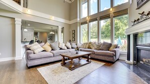 A spacious living room with a large sectional sofa, a wooden coffee table, and a fireplace.