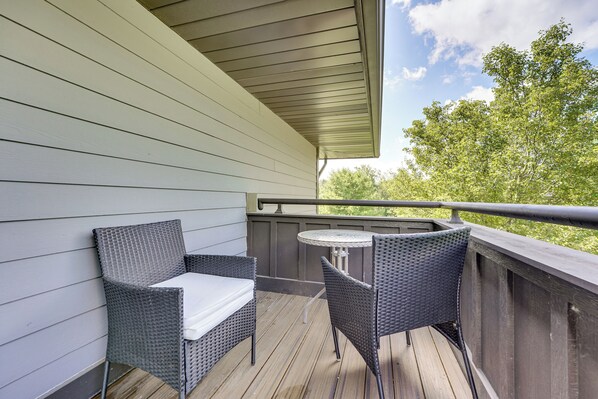 A balcony with wicker furniture and a small table.