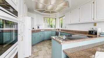 A modern kitchen with white cabinets, a granite countertop, and a large island.