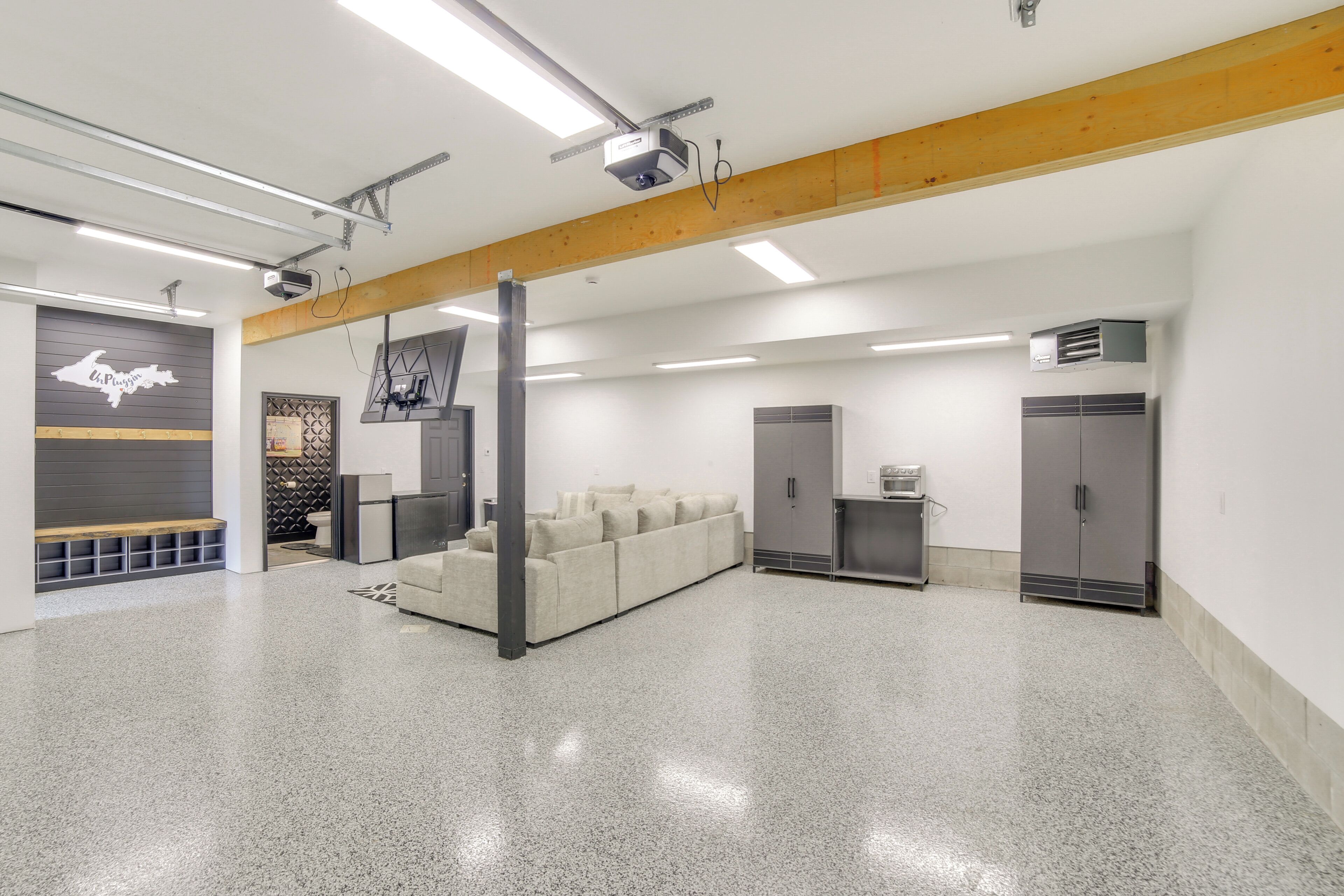 En rummelig, moderne lobby med en neutral farvepalette, et siddeområde og en projektionsskærm.