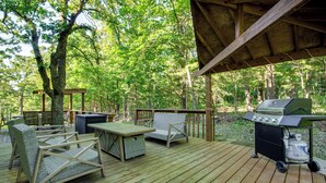 A wooden deck with outdoor furniture, including chairs and a table, and a barbecue grill. - Walk to Pomme de Terre Lake: Pet-friendly Escape (Flemington)