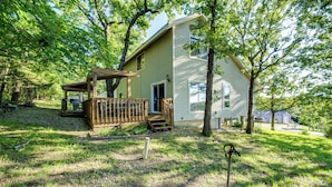 A single-story house with a covered porch and a small deck, surrounded by trees and a grassy yard. - Walk to Pomme de Terre Lake: Pet-friendly Escape (Flemington)