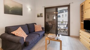 Ein Wohnzimmer mit einer Couch, einem Couchtisch und einem Fernseher.
