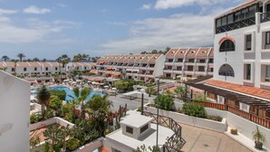 Ein Resort mit mehreren Gebäuden, einem Schwimmbad und üppiger Bepflanzung.