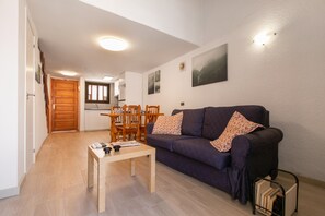 Un salon comprenant un canapé, une table basse et un coin repas avec des chaises et une table.