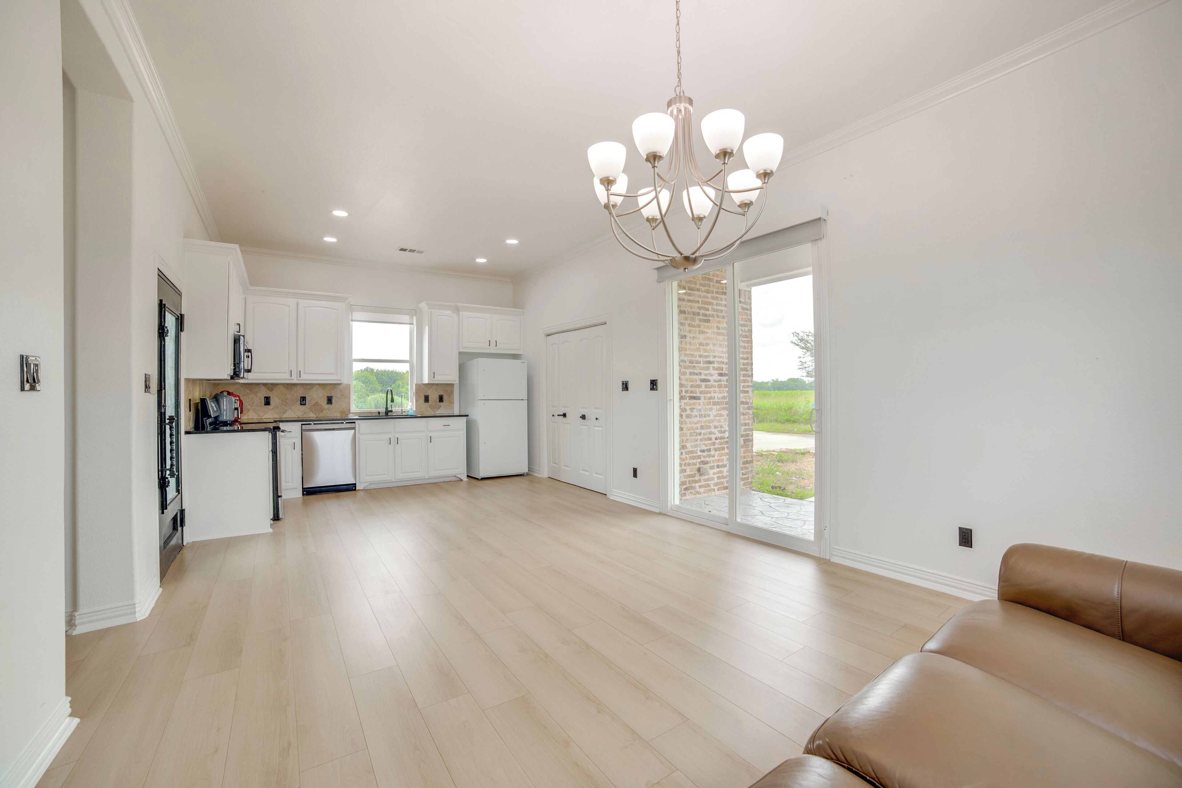 Una cocina amplia con armarios blancos, una isla central y un candelabro.