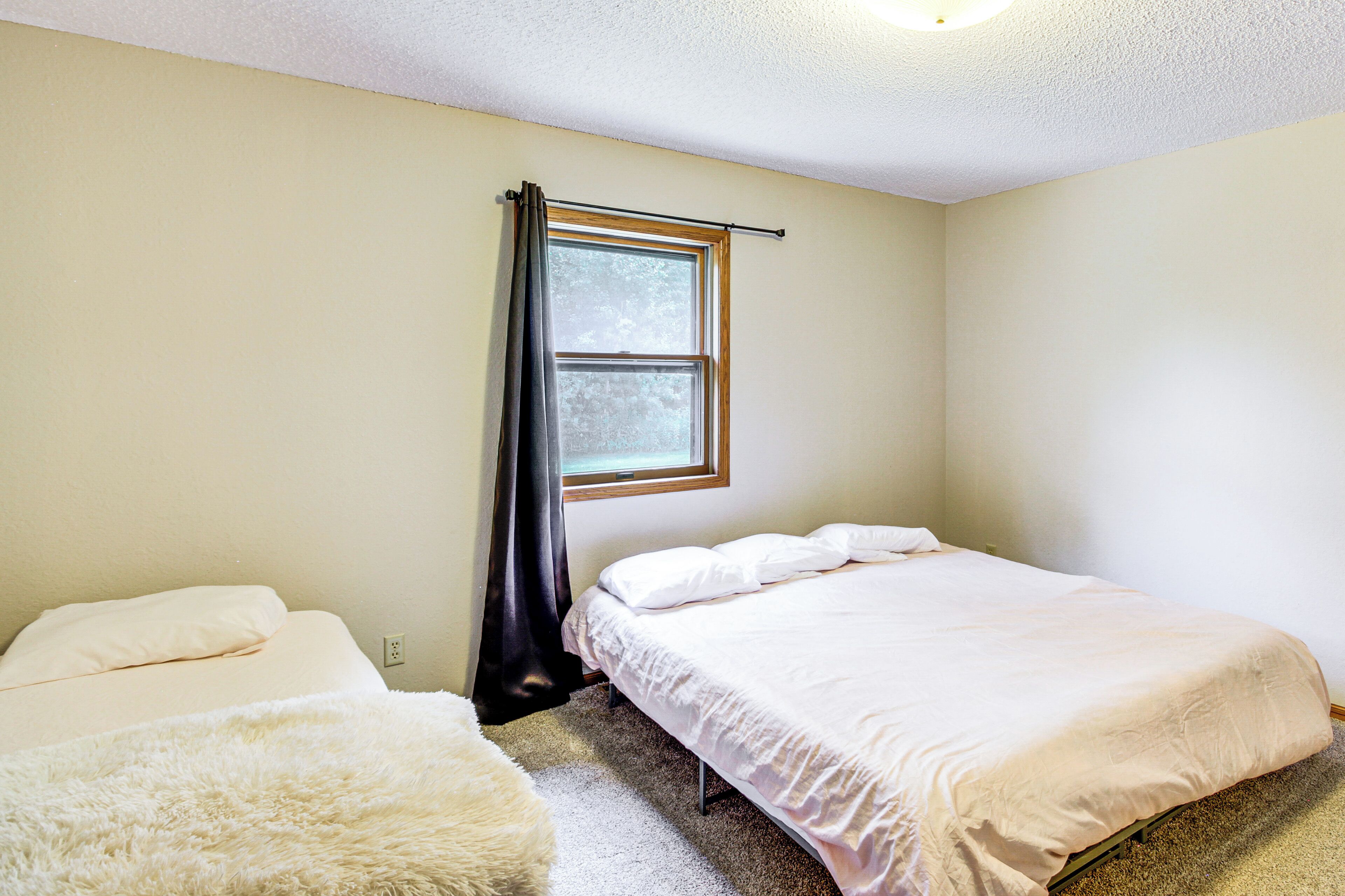 Une petite pièce propre, avec un lit simple, une fenêtre avec des rideaux et un tapis blanc moelleux.