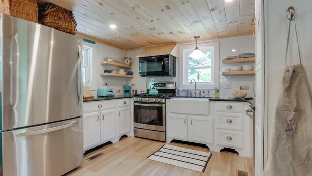 A modern kitchen with white cabinets, stainless steel appliances, and wooden flooring. - River Views & Boat Launch Access: Huntingdon Home (Huntingdon)