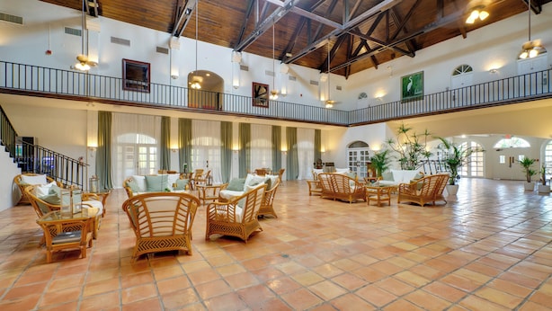 Eine großzügige Lobby mit hohen Decken, Holzböden und Rattanmöbeln.