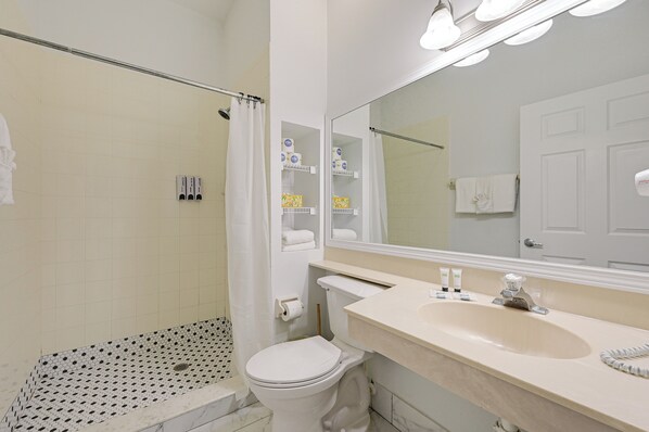 A bathroom with a shower, toilet, and sink.
