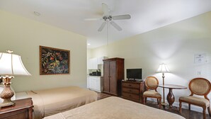 A hotel room with two beds, a ceiling fan, a painting, a desk with a lamp, a television, and a dining area with chairs and a table. - Dock, Pool & Tennis Courts: Naples Resort Retreat! (Naples)