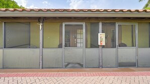 A building with a tiled roof, large windows, and a door with a security keypad. - Dock, Pool & Tennis Courts: Naples Resort Retreat! (Naples)