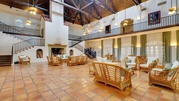 A spacious interior with a high ceiling, multiple levels, and a central staircase.