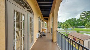 A covered balcony with a view of a green lawn and trees. - Resort on Marina: Everglades Escape on Heated Pool (Naples)