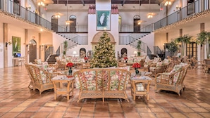 A spacious lobby with a central Christmas tree, multiple seating areas, and a staircase connecting floors. - Poolside Paradise w/ Dock in Everglades! (Naples)