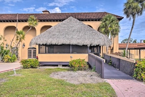 A building with a thatched roof, a wooden deck, and a paved walkway. - Swim, Sip, Sail: Everglades Escape at POI Resort (Naples)