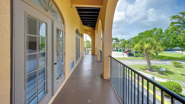 A covered balcony with a view of a parking lot and greenery. - Direct Access to 10,000 Islands: Everglades Escape (Naples)