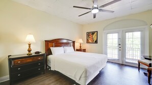 A bedroom with a bed, two bedside tables with lamps, a ceiling fan, and a door with a view of greenery outside. - Direct Access to 10,000 Islands: Everglades Escape (Naples)