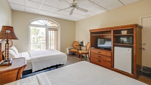 A hotel room with two beds, a desk, a chair, a television, a wardrobe, and a ceiling fan. - Hotel-style Studio 15 Mi to Everglades Nat'l Park (Naples)