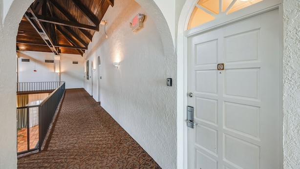 A hallway with a patterned carpet, white walls, and a wooden ceiling. - Hotel-style Studio 15 Mi to Everglades Nat'l Park (Naples)