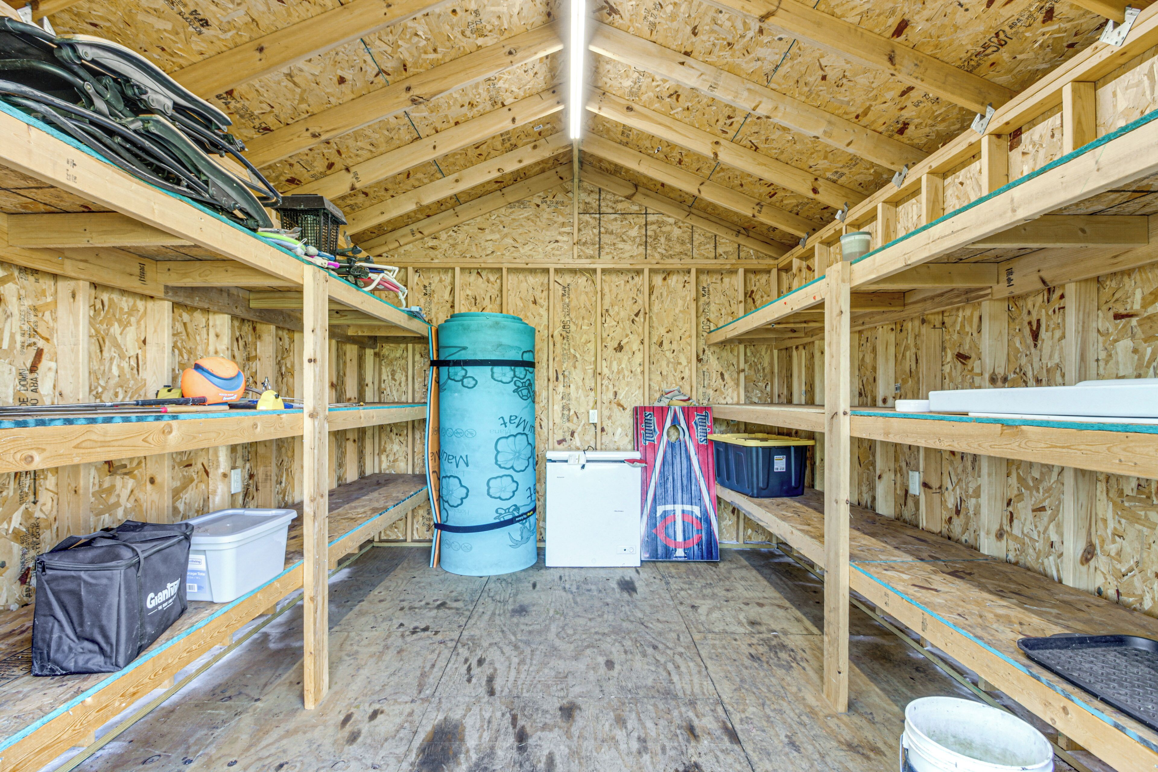 A wooden interior with bunk beds, a cylindrical object, and various items on shelves.