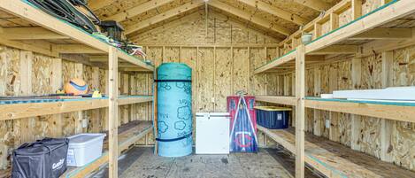 A wooden interior with bunk beds, a cylindrical object, and various items on shelves.