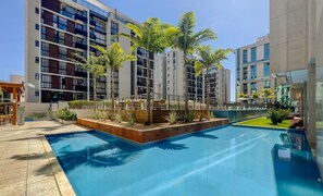 A modern hotel with a swimming pool, outdoor seating, and a well-maintained garden. - Charming Apartment in Brasilia/df Vps111 (Guará)