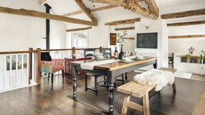 A dining area with a wooden table, chairs, and a bench. There is a dog on the bench. - Jackson s Barn in Water Yeat (Ulverston)