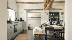 A modern kitchen with a central island, wooden beams, and a rustic bench. - Jackson s Barn in Water Yeat (Ulverston)