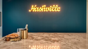 Moderni keittiö, jonka seinällä on neonvalomainos, jossa lukee ”Nashville”, sekä marmorinen työtaso ja erilaisia keittiövälineitä.