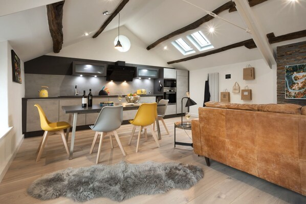 A modern kitchen with a dining area, a sofa, and a fluffy rug. - Wharton House Mews Retreat for two (Grange-over-Sands)