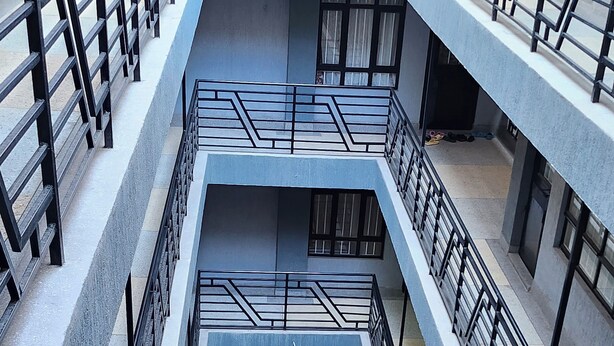 A multi-level building with a central atrium, featuring a geometric railing design and multiple floors with balconies. - Kingdom Corner Suites (Nairobi)