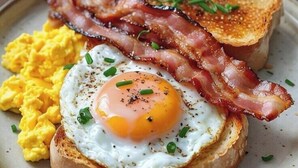 A breakfast plate with scrambled eggs, a fried egg, bacon, toast, and a glass of orange juice. - Kingdom Corner Suites (Nairobi)