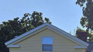 A two-story house with a front porch, a small window above the door, and a chimney. - Beautiful Wine Trail 2-BR Rental (Westfield)