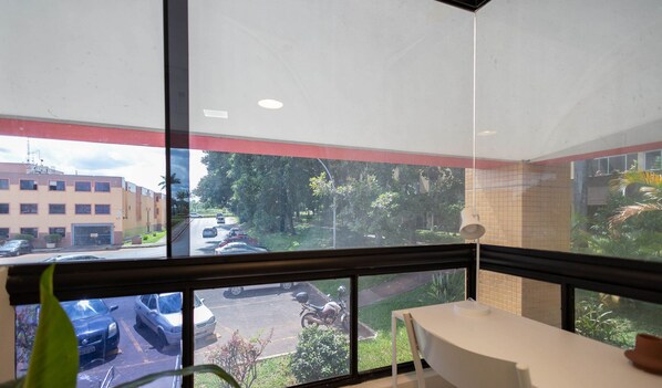 A room with a large window, a table, and a chair. - Studio Near the Park in Asa Norte Sce114 (Brasília)