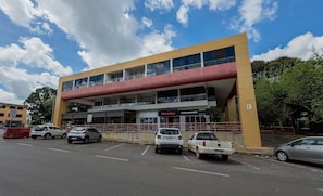 A two-story building with a yellow facade and a red overhang. - Studio Near the Park in Asa Norte Sce114 (Brasília)